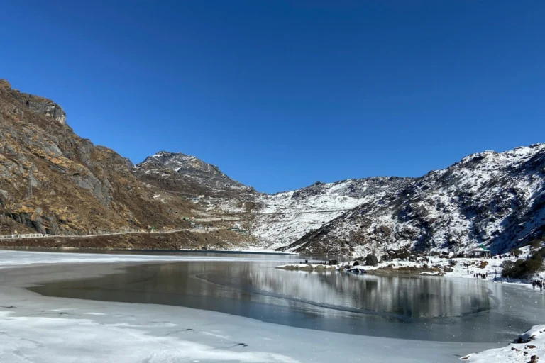 Frozen Tsomgo Lake surrounded by snow-covered mountains in Sikkim, North East India.