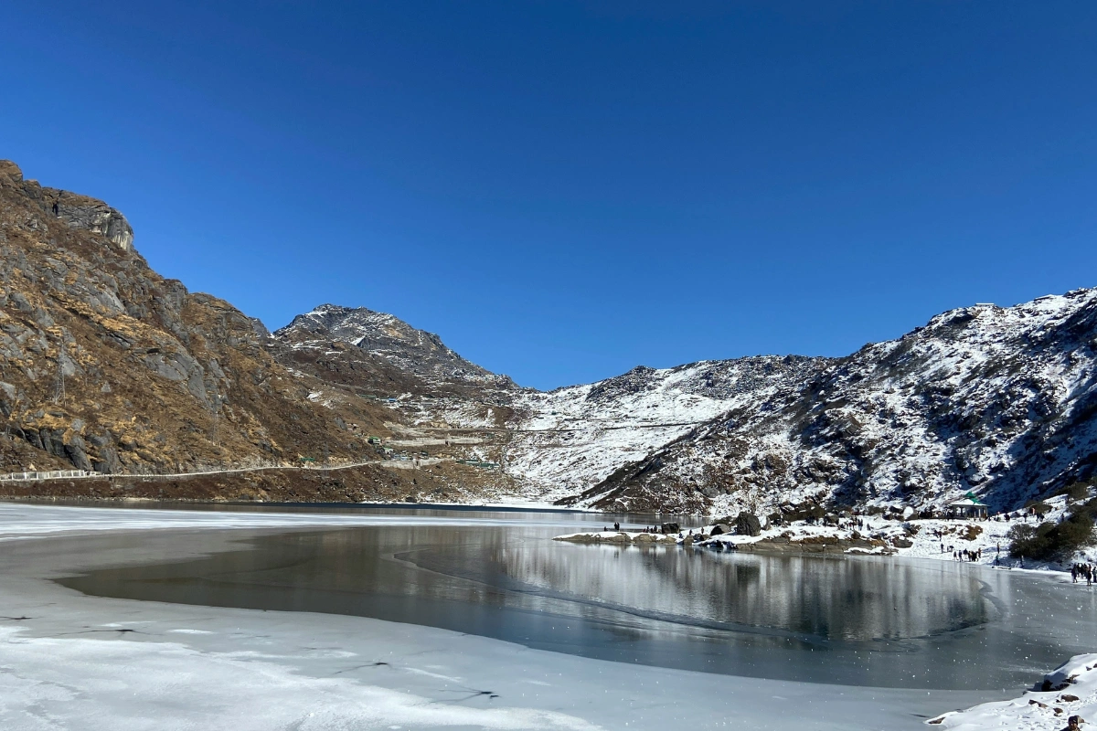 Frozen Tsomgo Lake surrounded by snow-covered mountains in Sikkim, North East India.