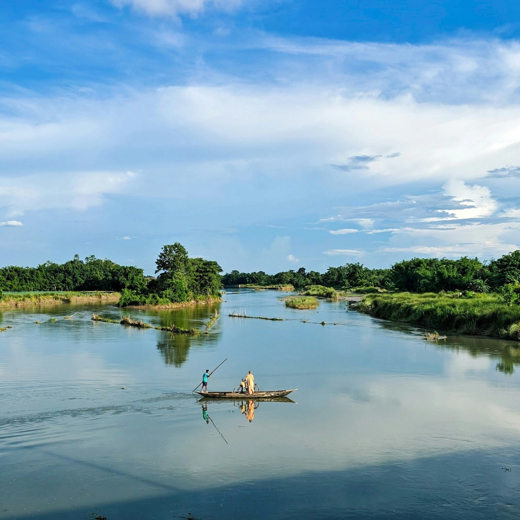 Boat ride on a calm river in Assam surrounded by lush greenery showcasing scenic nature in North East India