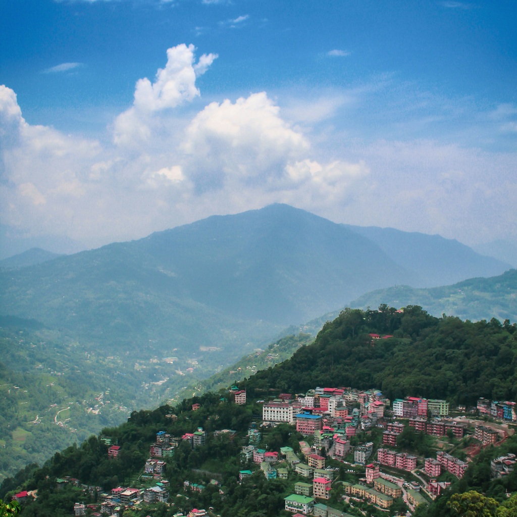 Scenic view of Gangtok city in Sikkim surrounded by lush green hills and misty mountains in North East India